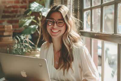 Una persona che fa ricerche su un laptop, circondata da nuvolette di pensiero con punti interrogativi e lenti d'ingrandimento.