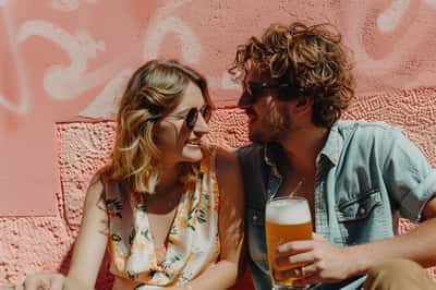 Una persona che guarda delusa un appuntamento, con una nuvoletta di pensiero che mostra uno scenario romantico idealizzato e irrealistico.