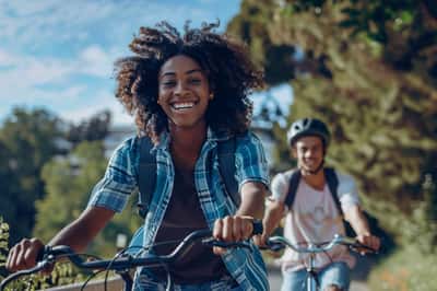 Una coppia di adolescenti va in bicicletta insieme su un sentiero, godendosi l'aria aperta e la natura.