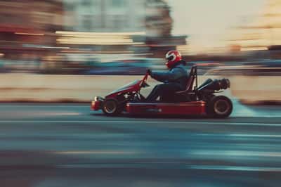 Un uomo e una donna sui go-kart, che corrono e sorridono su una pista.