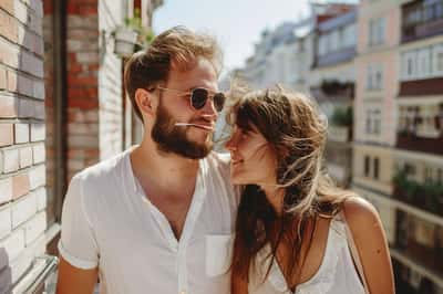 Un uomo e una donna a un primo appuntamento leggero, che condividono un dessert e ridacchiano.
