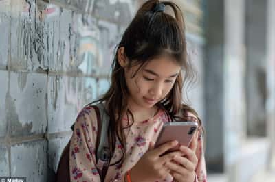 Zwei Mittelschüler an ihren Handys, wahrscheinlich folgen sie einander in den sozialen Medien, mit glücklichen Ausdrücken.