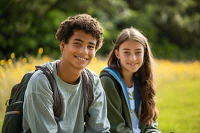 Ein Junge und ein Mädchen spielen Frisbee in einem Park und genießen die Zeit zusammen außerhalb der Schule.