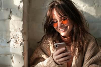 7. Smaž ho ze svých účtů na sociálních sítích Ruka držící chytrý telefon, s prstem visícím nad tlačítkem 'smazat' na profilu sociální sítě.