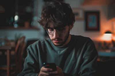 Una persona che si stringe nelle spalle con un'espressione rilassata, indicando aspettative ridotte.