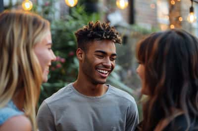 Un uomo sorride calorosamente a una donna, i suoi occhi si increspano di felicità genuina.