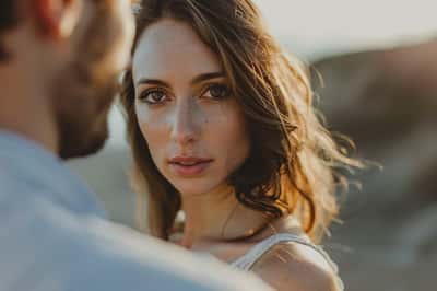 Žena vypadá smutně a vzdáleně, drží zarámovanou fotografii sebe a bývalého partnera.