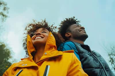 Zwei Personen, ein Ex-Paar, lächeln und schütteln sich die Hände, was zukünftige Freundschaft symbolisiert.